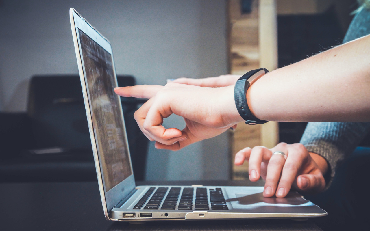 TPI header image with people pointing at laptop screen