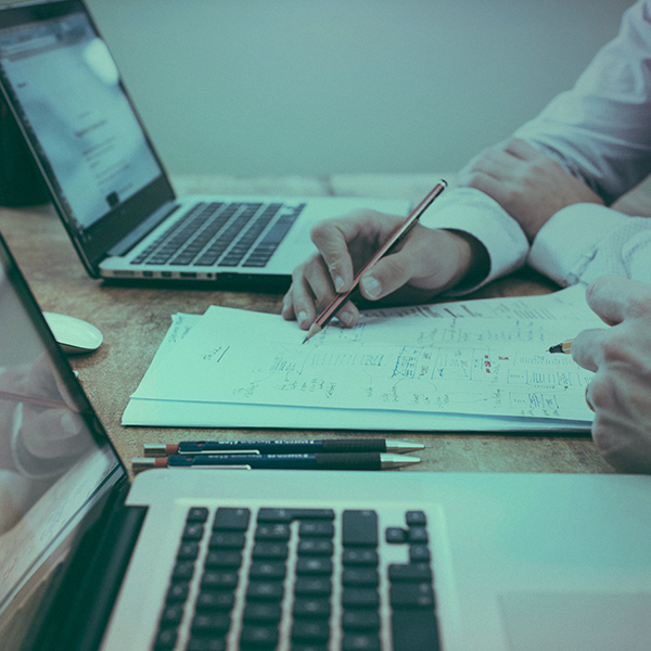 People working out finances with laptops on an office desk