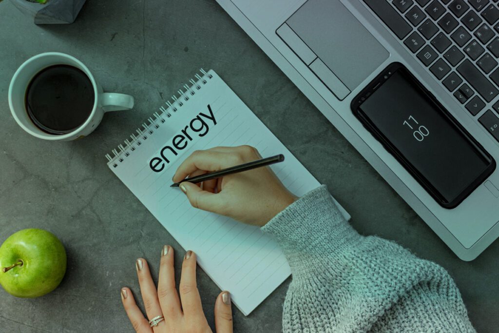 Woman writing on a notepad, preparing to tick off a small business energy checklist
